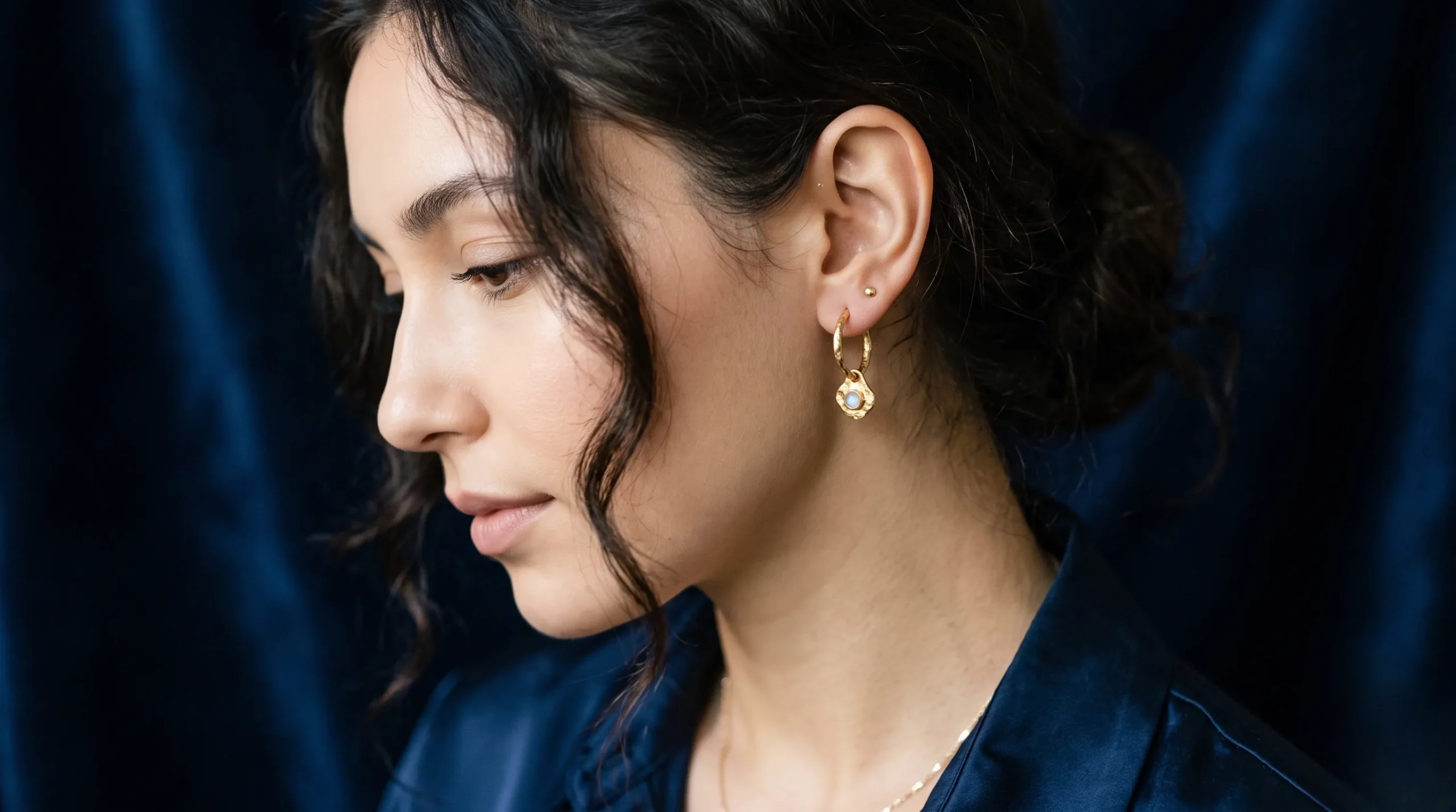 Boucle d'oreille élégante sous une lumière lunaire pour illustrer le symbolisme de l'oreille gauche chez l'homme.